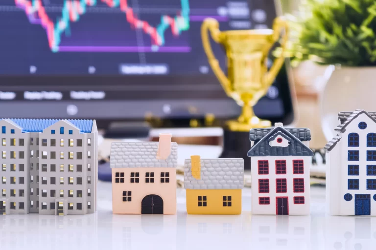 Real estate investment concept with miniature houses and financial market chart