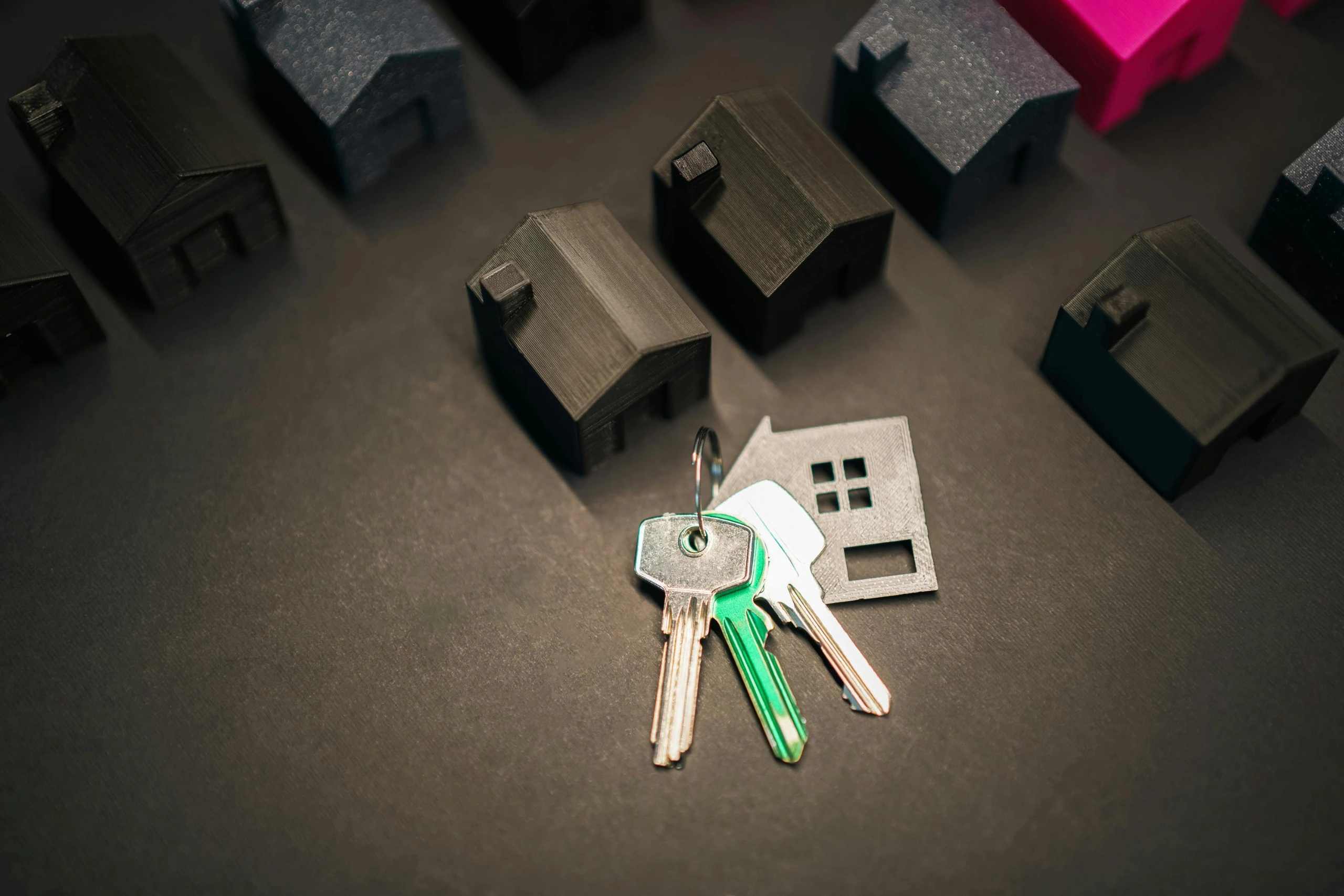 House keys with model homes representing self-managing vs hiring a property manager for rental properties